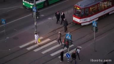高角度拍摄的人过马路的绿色红绿灯在晚上的<strong>公共汽车</strong>和电车等待
